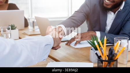 Les hommes d'affaires se serrer la main après la signature d'entente Banque D'Images