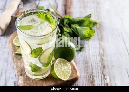 Cocktail de mojito frais avec citron vert, menthe et glace en verre sur table en bois Banque D'Images