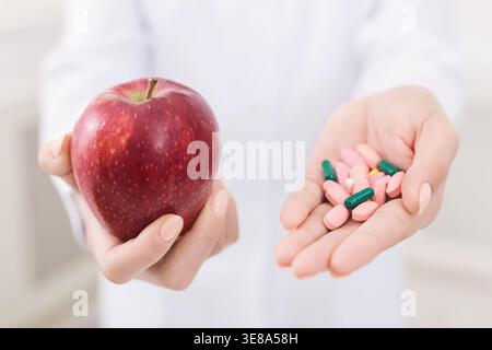 Docteur tenant pomme et pilules dans les mains Banque D'Images