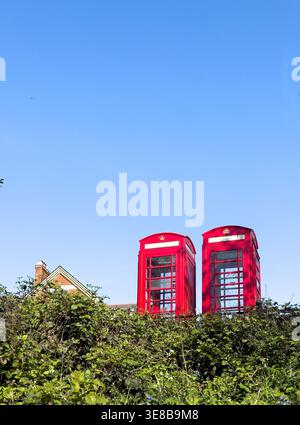 08 avril 2026 - Londres, Royaume-Uni - deux boîtes téléphoniques traditionnelles britanniques rouges par un jour de ciel bleu ensoleillé Banque D'Images