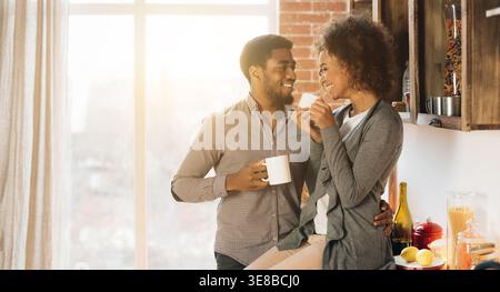 Joli jeune couple boire du café dans la cuisine Banque D'Images
