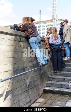 Zuschauer nutzen das Geländer, um über die Mauer zu sehen, am Platz Sergels Torg in der Innenstadt von Stockholm, Schweden *** les spectateurs utilisent le rail Banque D'Images