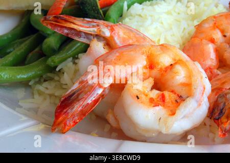 Une crevette géante est enroulée et placée sur un lit de riz avec des légumes, servi comme salade de crevettes, dans un restaurant de fruits de mer Banque D'Images