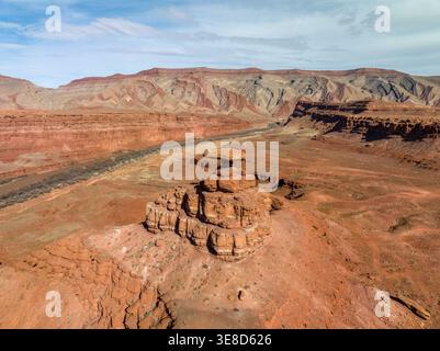 Vue aérienne de la formation rocheuse Mexican Hat près de la rivière San Juan, Utah. Caprock de grès équilibré dans une vaste vallée désertique de roches rouges. Banque D'Images