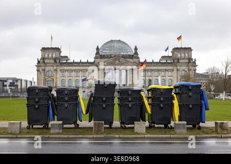 Reichstag Berlin avec des drapeaux allemands agités. Il y a des bennes à ordures d'un événement majeur devant elle. Berlin, Allemagne Banque D'Images