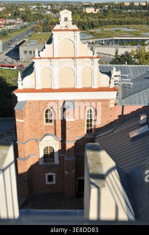 Vue en angle élevé de la façade de la chapelle de la Sainte Trinité au château de Lublin, montrant le pignon décoratif et la brique sur fond de ville, Lublin, po Banque D'Images