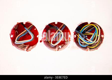 Câblage électrique dans les prises murales à l'intérieur non fini, trois boîtes d'installation avec câbles. Concept : installation électrique Banque D'Images