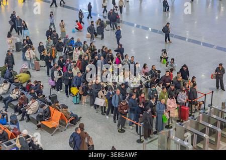 Hangzhou, Chine - 11 décembre 2025 : foule de gens qui attendent et marchent dans une grande gare moderne en Chine. Banque D'Images