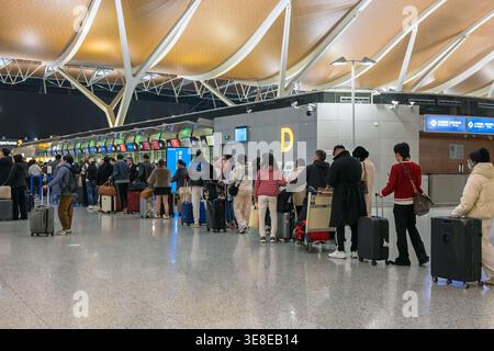 Shanghai, Chine - 11 décembre 2025 : les passagers attendent dans une longue file d'attente aux comptoirs d'enregistrement de l'aéroport international de Pudong Banque D'Images