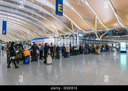 Shanghai, Chine - 11 décembre 2025 : les passagers attendent dans une longue file d'attente aux comptoirs d'enregistrement de l'aéroport international de Pudong Banque D'Images