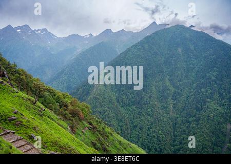 Cette image capture un paysage montagneux à couper le souffle près du temple Madmaheshwar dans l'Uttarakhand, en Inde. La scène présente une végétation luxuriante, des collines ondulantes, Banque D'Images