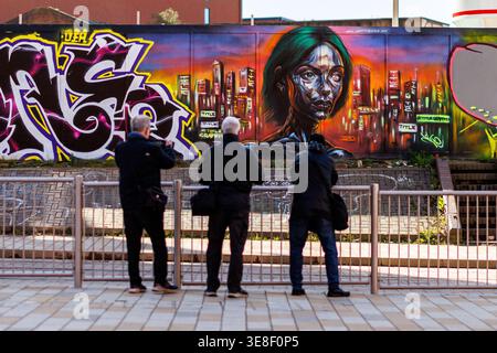 Trois photographes prenant une photo de quelques œuvres d'art graffiti d'une femme futuriste robotique à Digbeth Birmingham sur le facteur outsidecustard de la rue Banque D'Images