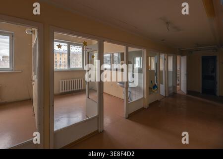 Regardant d'un couloir dans des chambres vides et interconnectées d'un hôpital pédiatrique soviétique abandonné (russe). Banque D'Images