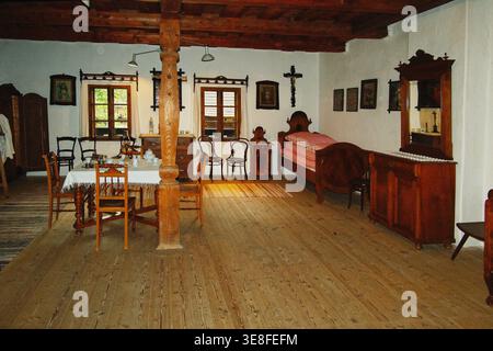 Salle commune généreuse dans le village tchèque présentant des plafonds à poutres en bois et des décorations classiques faites à la main Banque D'Images