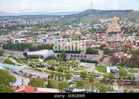 Une vue panoramique de Tbilissi, Géorgie montrant la cathédrale Sainte-Trinité au dôme doré, les parcs au bord de la rivière, les structures modernes de Rike Park et le voisin historique Banque D'Images