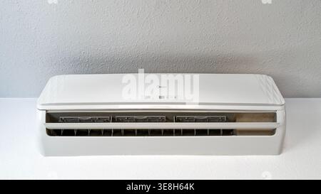 Un climatiseur mural Midea sur un mur de plâtre blanc Banque D'Images