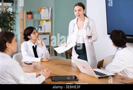 Jeune femme médecin dirigeant une réunion médicale en cabinet Banque D'Images