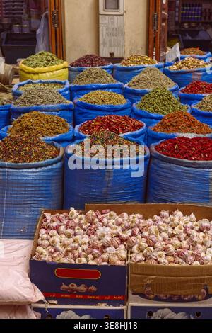 293 herbes séchées et épices dans des sacs en plastique, bulbes d'ail dans des boîtes en carton, marché aux épices de l'ancien Mellah ou quartier juif. Marrakech-Maroc. Banque D'Images