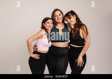 Concept de fraternité. Belles amies féminines câlin plus taille Curvy femme dans le portrait de sport studio. Diverses femmes expriment l'amitié, Body positivit Banque D'Images
