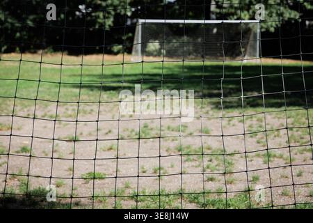 Vue à travers un filet de but de football vers un terrain vide et deuxième but dans un parc à Glen Rock, New Jersey. Banque D'Images