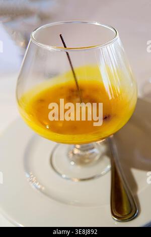 Dessert aux fruits de la passion ou cocktail en verre avec gousse de vanille, mousse d'orange tropicale ou martini à texture de graines, boisson sucrée gourmande, restaur exotique Banque D'Images