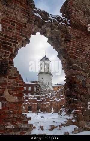 Vue sur l'ancienne tour de l'horloge à travers un mur de briques en ruines. Beffroi de la cathédrale de Vyborg, Vyborg, Russie. Banque D'Images