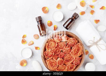 Bouteille d'huile essentielle, fleur de rose dans le bol, serviette et bougies sur la vue de dessus de table en pierre. Spa, aromathérapie, bien-être, fond de beauté Banque D'Images