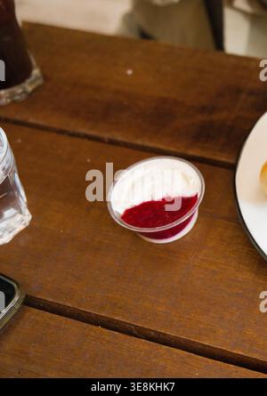 Fromage à la crème isolé récolte de détail de bagel ordinaire avec fromage à la crème framboise. Cette image présente du fromage à la crème, de la confiture de framboises, une tasse à confiture. Fraîchement cuit Banque D'Images