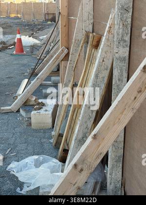 Chantier de construction avec poutres et matériaux en bois dispersés, avec textures usées et débris. Photo mobile Banque D'Images