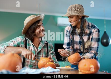 Halloween, heureux et couple avec citrouille pour la sculpture à la fête, la célébration et l'esthétique effrayante. Vacances, costume et homme avec femme avec légume Banque D'Images