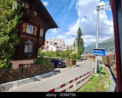 Vue depuis le train en passant par la rue du village St Moritz avec des maisons suisses traditionnelles Banque D'Images