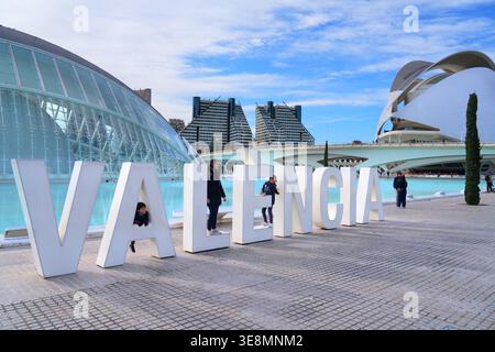 VALENCIA, ESPAGNE - 6 JANVIER 2026 : les touristes visitent le panneau de nom de la ville de Valence à Valence, Espagne. Partie du complexe de la Cité des Arts et des Sciences. Banque D'Images