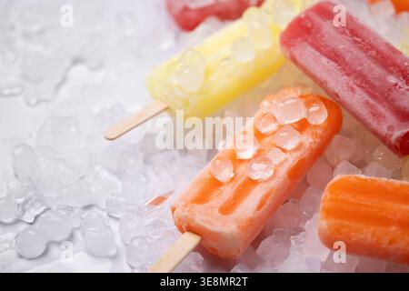 Popsicles de fruits colorés sur de la glace pilée. Concept de rafraîchissement estival Banque D'Images
