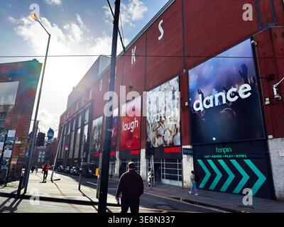 Manchester, Royaume-Uni - 22 février 2026 : vue sur la rue du complexe de divertissement Printworks à Manchester Royaume-Uni avec affiches audacieuses, piétons et soleil fort Banque D'Images