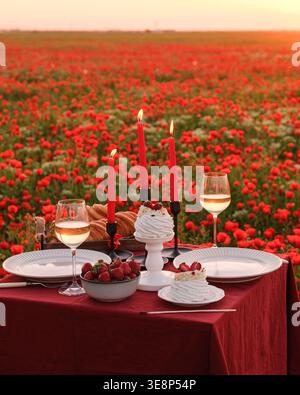 Cadre intime pour dîner aux chandelles. Repas romantique confortable avec des verres chatoyants et des fleurs vibrantes Banque D'Images