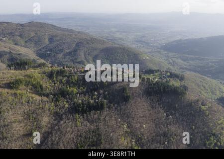 Vue aérienne du village historique de Trappola situé sur une crête de montagne au milieu de forêts denses et collines vallonnées Trappola, Toscane, Italie. Banque D'Images