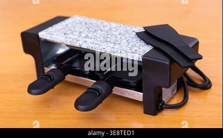 Gril de table servant un plat suisse de raclette Banque D'Images