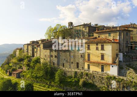 Vue aérienne des maisons en pierre historiques et des toits en terre cuite de Trappola niché sur une colline luxuriante à Trappola, Toscane, Italie. Banque D'Images