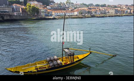 Vue panoramique sur le quartier historique de Ribeira à Porto le long du fleuve Douro, avec des maisons traditionnelles colorées, l'emblématique pont Dom Luís I, et le th Banque D'Images
