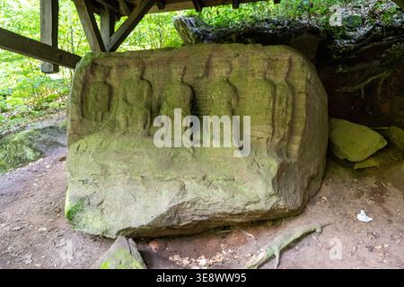 Vue de face d'un bloc de grès sculpté montrant plusieurs personnages humains au sanctuaire romain de Heidenfelsen dans le Pfälzerwald près de Landstuhl, GE Banque D'Images