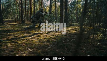 Soldat allemand accroupissant et visant un fusil dans la forêt pendant le combat Banque D'Images