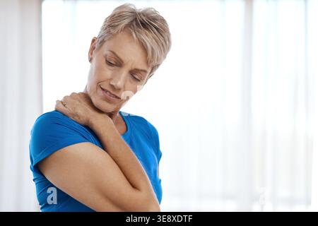 Douleur au cou, maison et femme âgée avec blessure pour tendinite, arthrose et mauvaise posture. Espace, retraite et personne avec tension, tension et Banque D'Images
