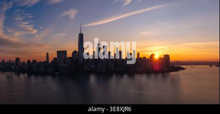 Vue aérienne de l'aube et de Lower Manhattan gratte-ciel au-dessus de l'Hudson River, New York City. Gratte-ciel et front de mer urbain au lever du soleil Banque D'Images