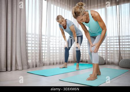 Yoga, amis et femme mature avec douleur au genou pour blessure, erreur de forme physique ou accident en studio. Classe, matin et personne avec tension, pression et Banque D'Images