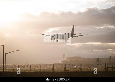 Les avions commerciaux de passagers en approche finale de l'aéroport de Londres Heathrow se silhouettaient contre un spectaculaire ciel de coucher de soleil à l'heure d'or. Banque D'Images