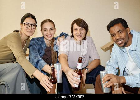 Portrait de divers amis célébrant l'emménagement avec un verre Banque D'Images