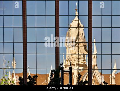 La salle de l'Assemblée se reflète dans un bâtiment en verre à Salt Lake City, Utah. Les caractéristiques architecturales distinctes sont visibles dans le reflet. Banque D'Images