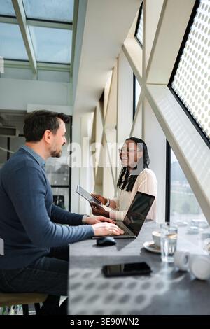 Divers professionnels collaborant sur ordinateur portable et tablette Banque D'Images