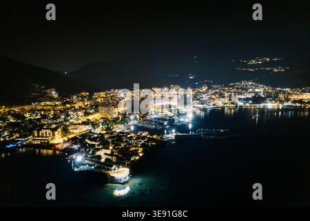 Port de nuit serein. Ville côtière tranquille brille de reflets sur les eaux douces la nuit Banque D'Images