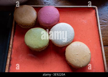Macarons français sur une assiette rouge carrée lors d'un buffet Banque D'Images